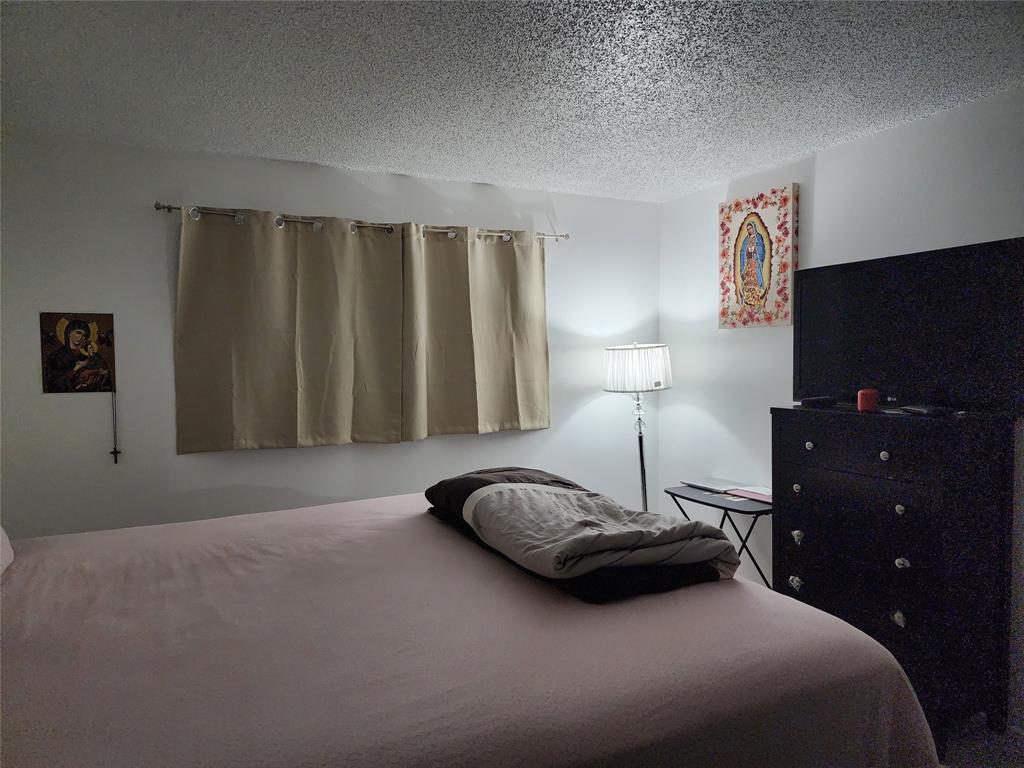 8020 Fairview Drive, Unit 109 Tamarac, FL 33321 - Photo 9 of 12 a bedroom with a bed and lamp