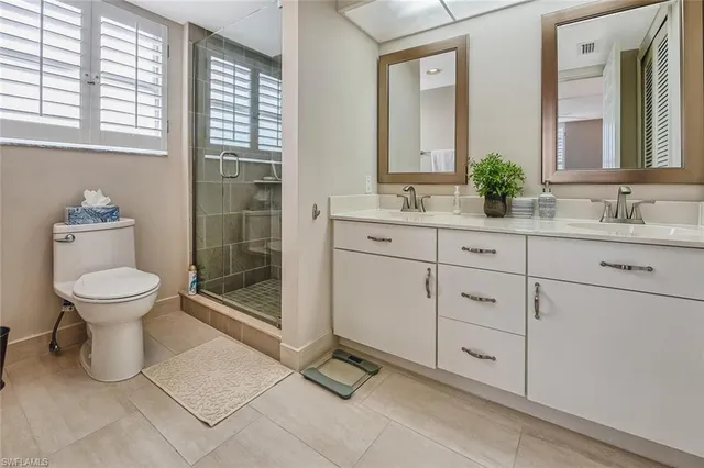 a spacious bathroom with 2 sink toilet and shower