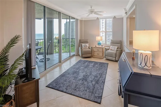 a living room with furniture and a floor to ceiling window