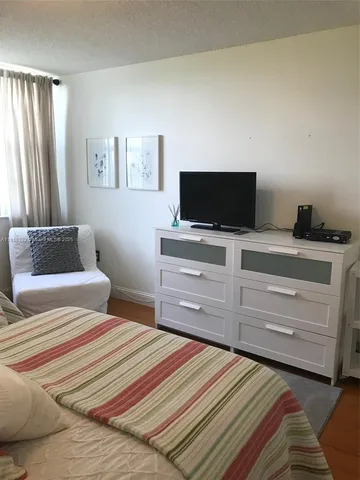 a bedroom with a bed and flat screen tv