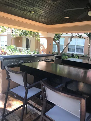 a view of patio with chairs and tables under an umbrella