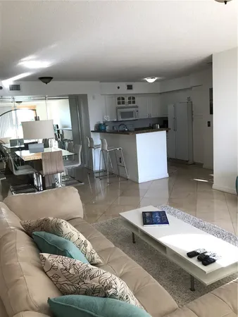 a living room with lots of furniture and kitchen view