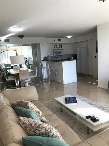 a living room with lots of furniture and kitchen view