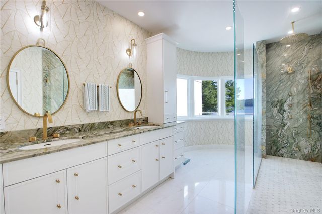 a bathroom with a granite countertop double vanity sink and a mirror
