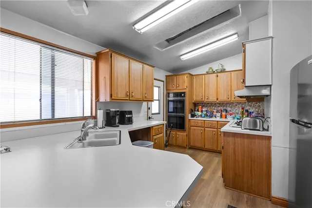 a kitchen with granite countertop a refrigerator stove top oven and sink