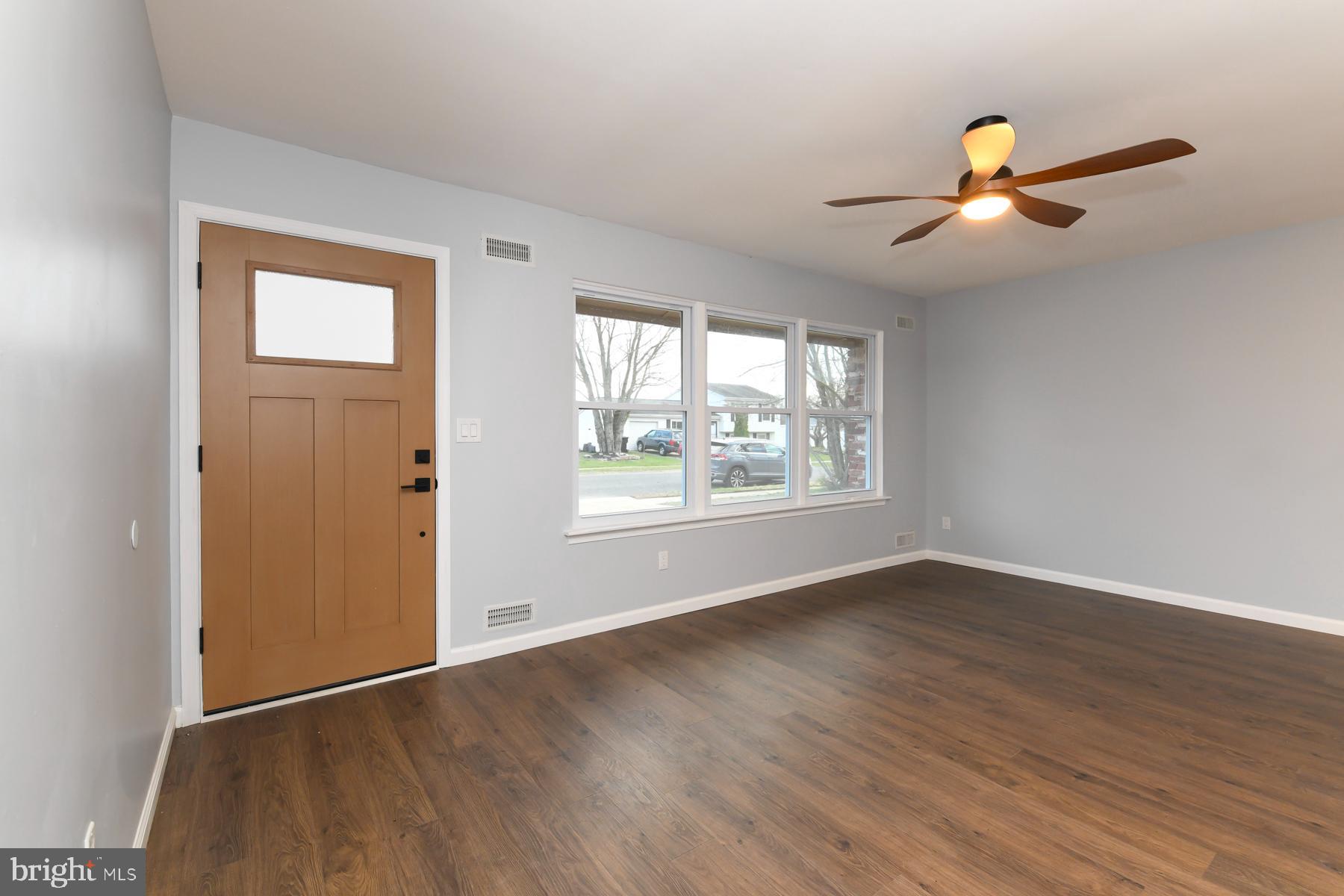 10 Ivy Lane Sicklerville, NJ 08081 - Photo 6 of 30 an empty room with wooden floor chandelier fan and windows
