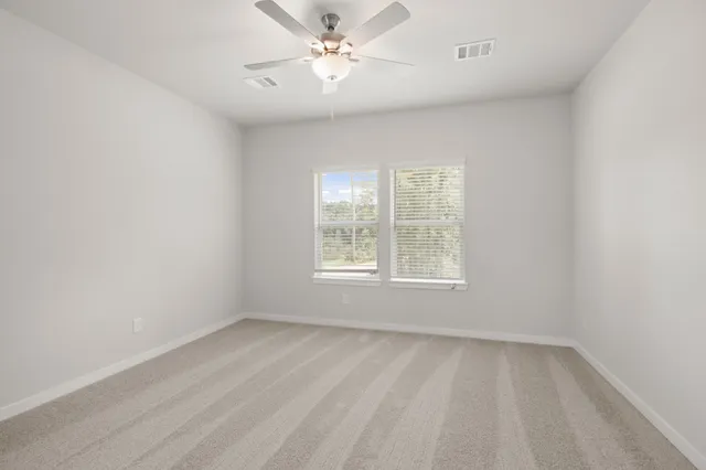 an empty room with a window and a fan