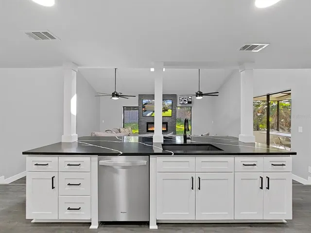 a kitchen with white cabinets and sink