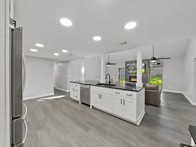 a large kitchen with granite countertop a sink and a stove top oven