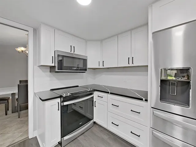 a kitchen with white cabinets and stainless steel appliances