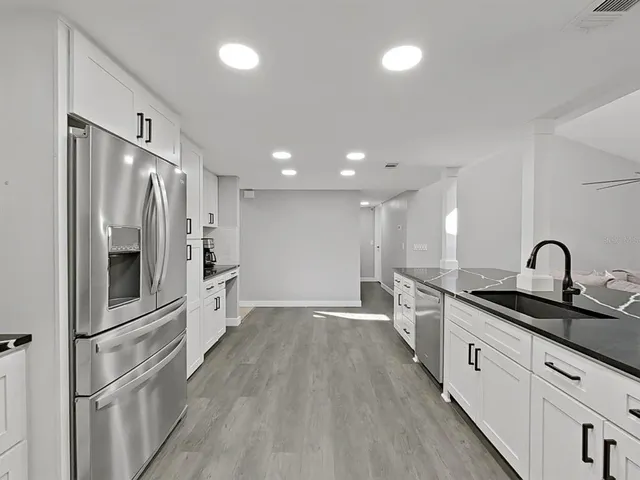 a kitchen with white cabinets and stainless steel appliances
