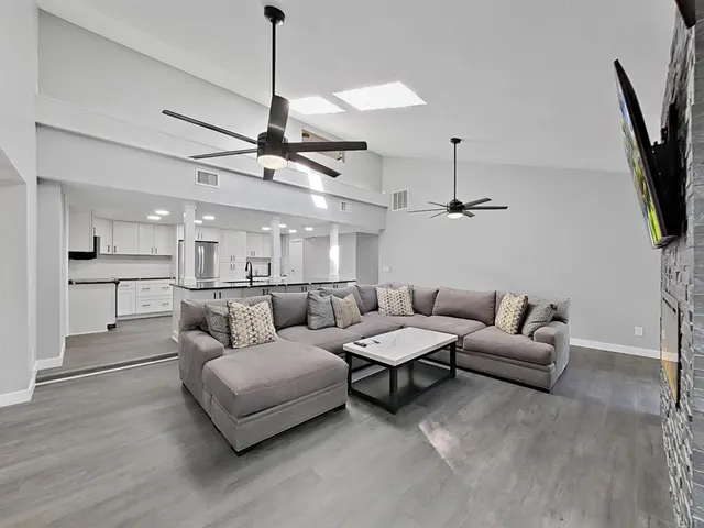 a living room with furniture and a ceiling fan
