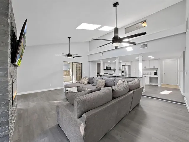 a living room with furniture a ceiling fan and a flat screen tv