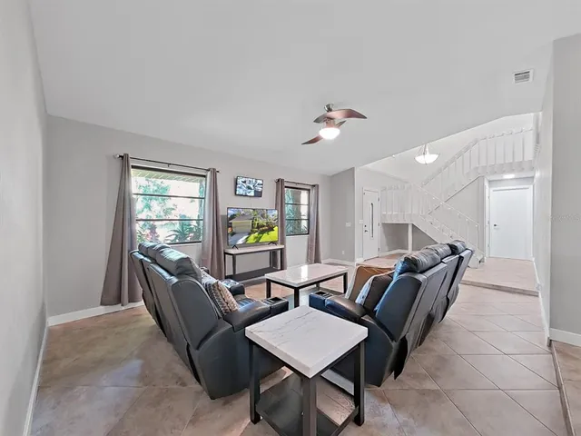 a living room with furniture and a wooden floor