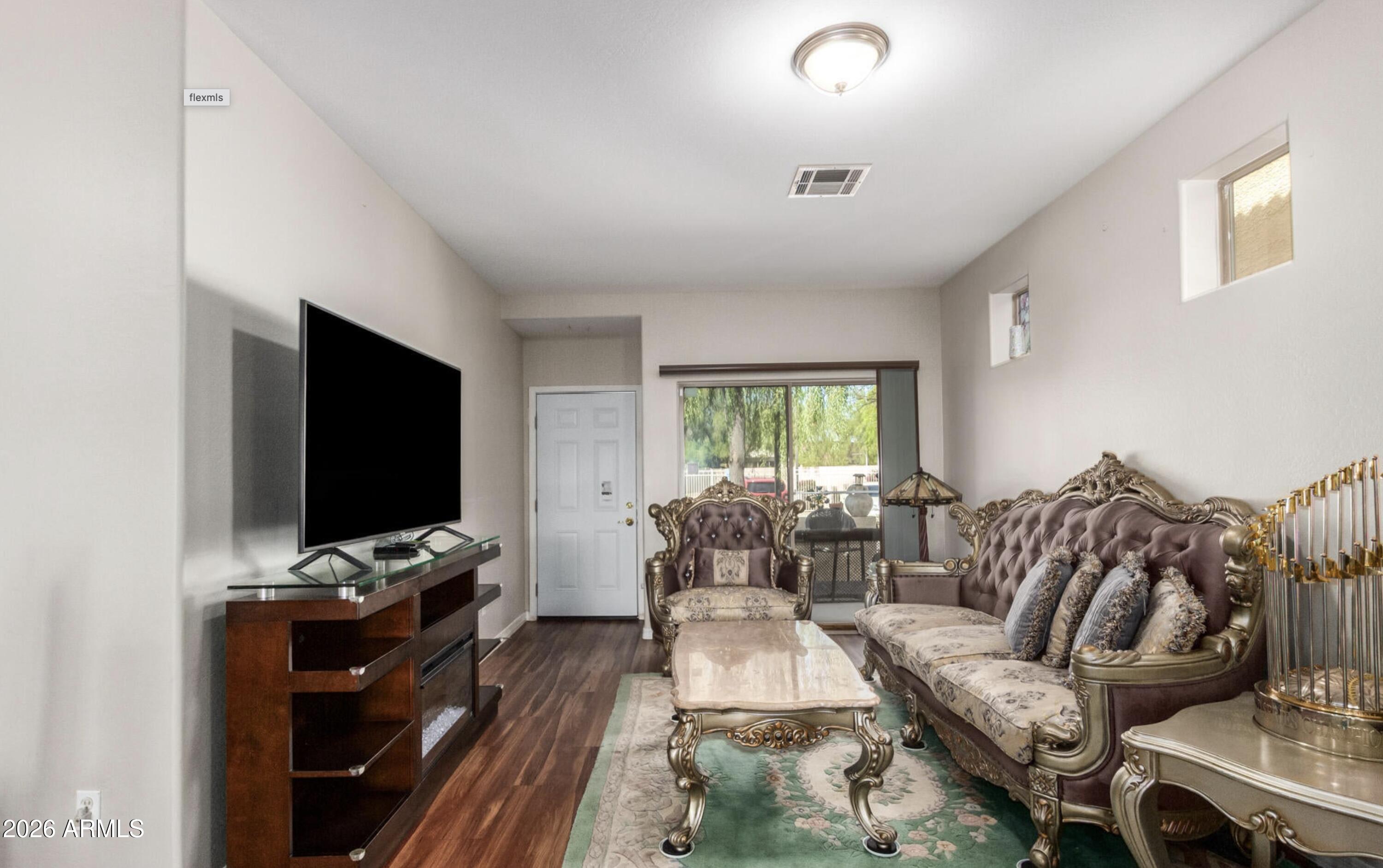 10225 West Camelback Road, Unit 12 Phoenix, AZ 85037 - Photo 5 of 19 a living room with furniture and a flat screen tv