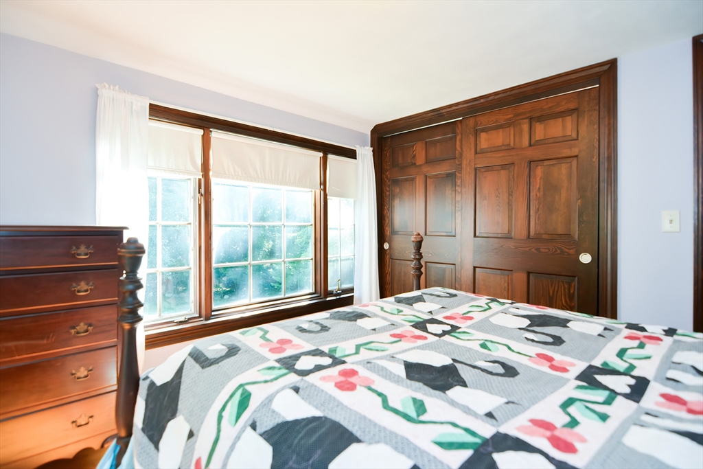 359 Taylor Road Stow, MA 01775 - Photo 25 of 36 a bedroom with a bed and a dresser next to a window