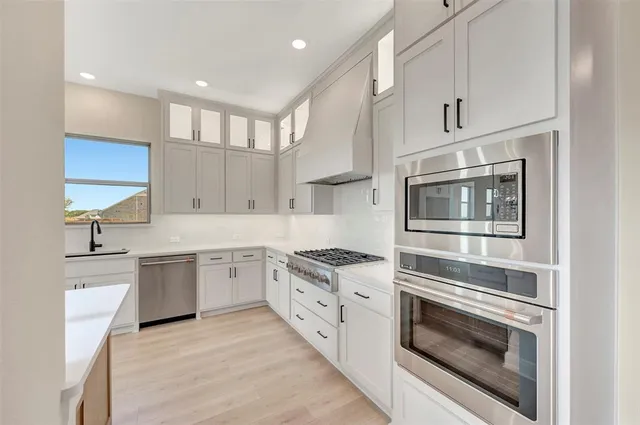 a kitchen with granite countertop a sink stainless steel appliances and cabinets