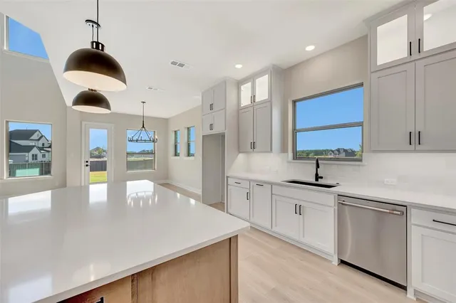 a large room with kitchen island a sink a center island stainless steel appliances and a cabinets