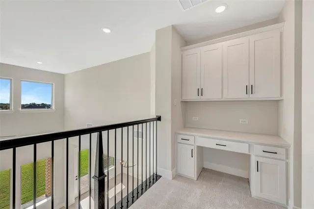 an empty room with ceiling fan and windows