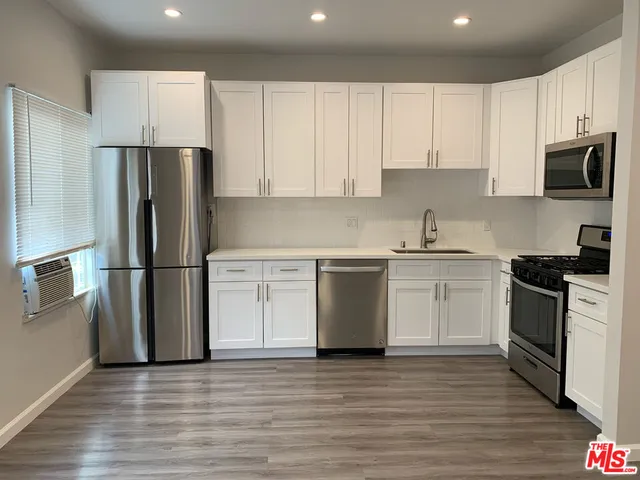 a kitchen with a refrigerator sink and white cabinets