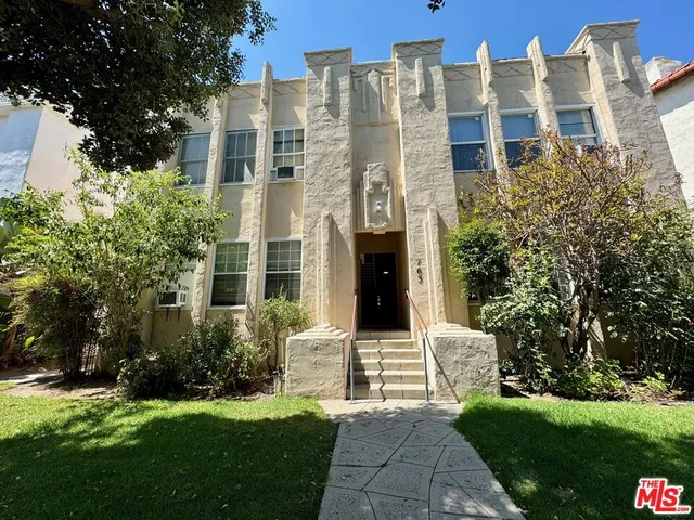a front view of a residential apartment building with a yard