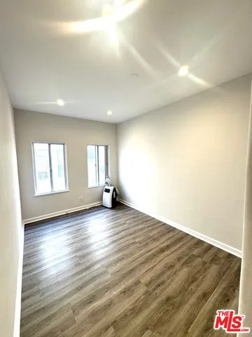 an empty room with wooden floor and window