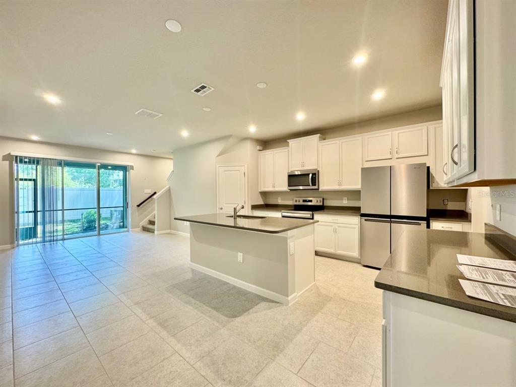 3247 Feather Hvn Place Brandon, FL 33511 - Photo 4 of 34 a open kitchen with stainless steel appliances granite countertop a stove a sink a microwave and a refrigerator