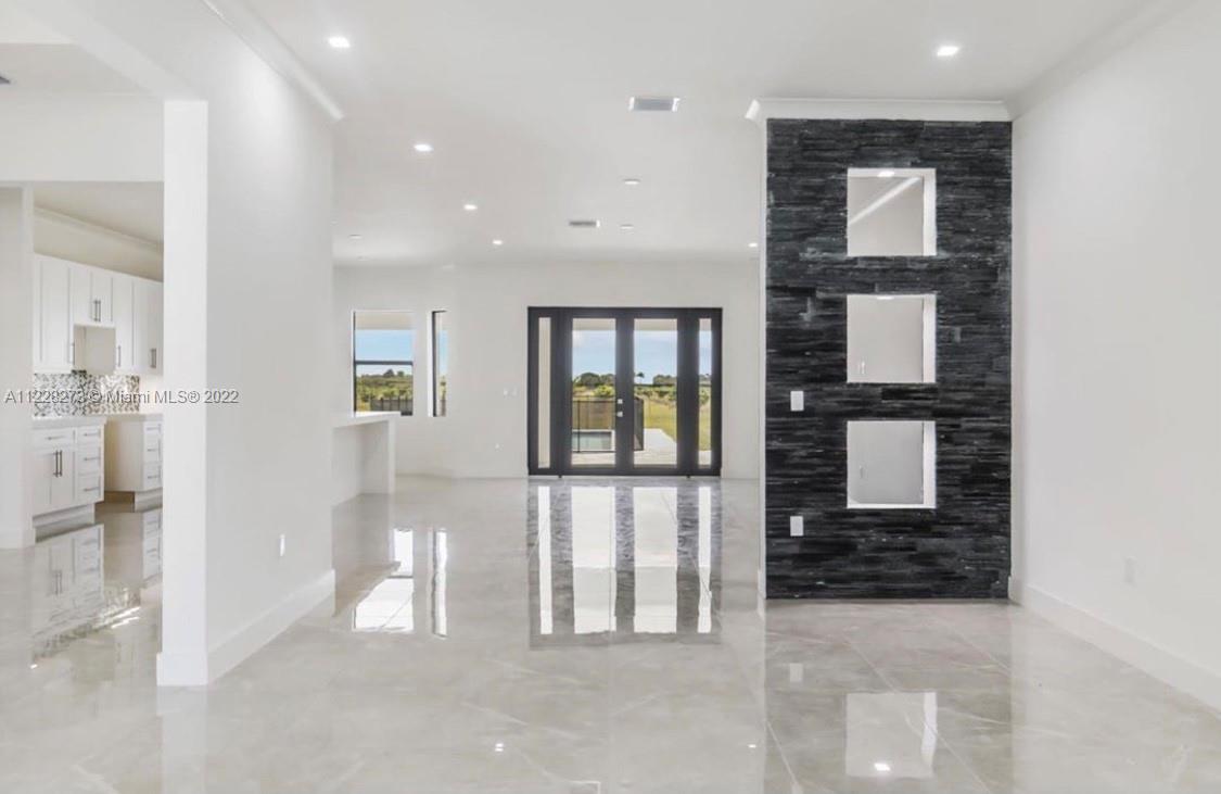 18830 Southwest 354th Street Homestead, FL 33034 - Photo 12 of 14 a view of a hallway with wooden floor and a living room