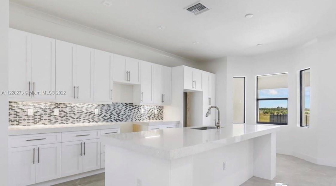 18830 Southwest 354th Street Homestead, FL 33034 - Photo 6 of 14 a kitchen with white cabinets and window