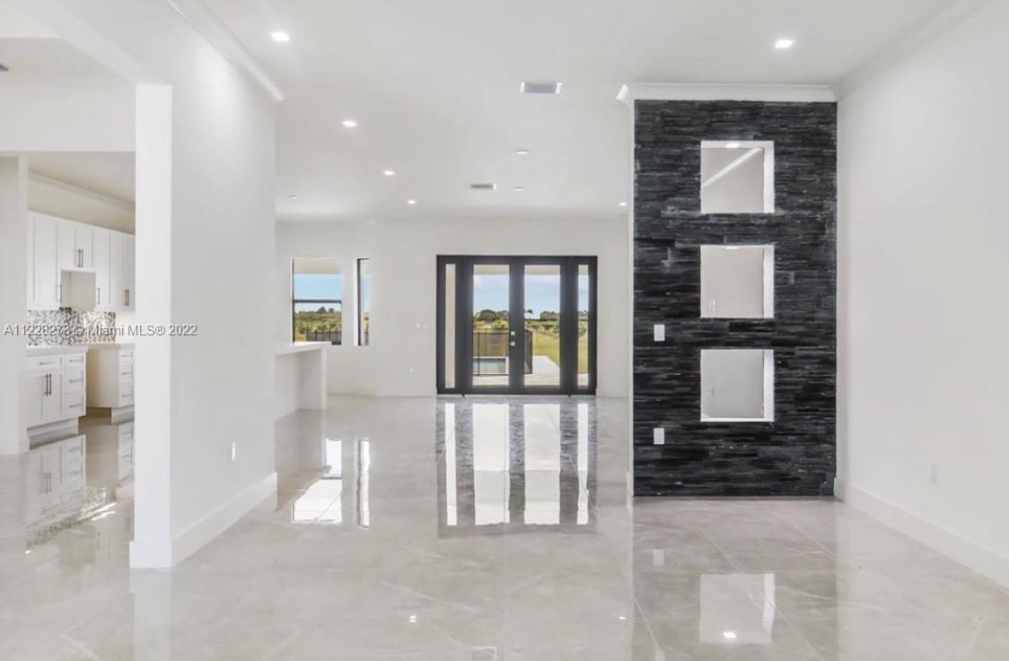 18830 Southwest 354th Street Homestead, FL 33034 - Photo 8 of 14 a view of a hallway with wooden floor and a living room