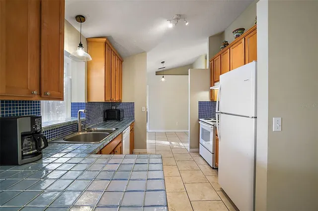 a kitchen with a stove top oven and refrigerator