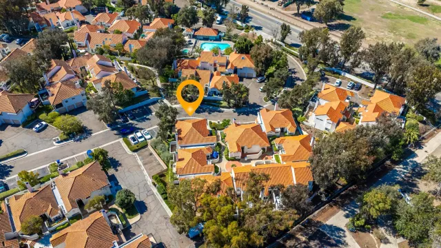 an aerial view of residential houses with outdoor space and trees