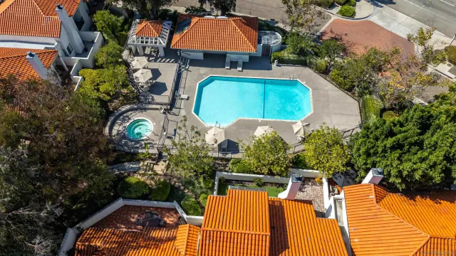 an aerial view of a house with a yard and a large tree
