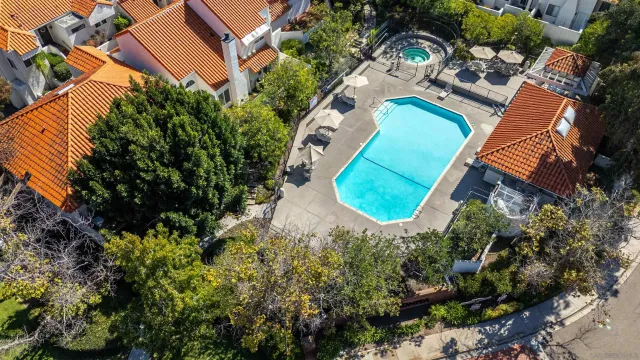 an aerial view of a house with swimming pool and lawn chairs under an umbrella