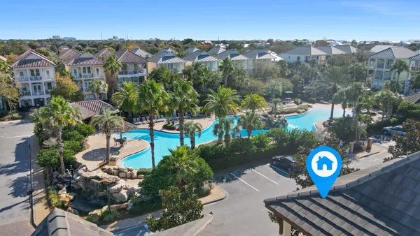 an aerial view of a house with a swimming pool and outdoor seating