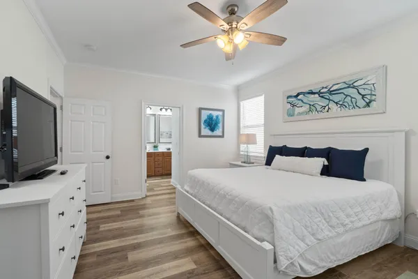 a spacious bedroom with a bed and a flat screen tv