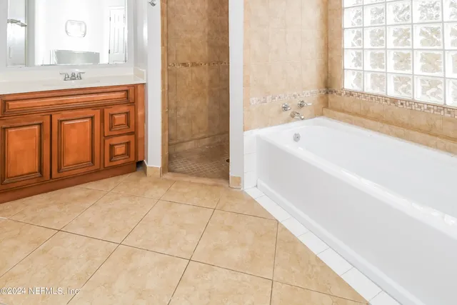 a bathroom with a tub sink and a mirror