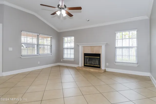 an empty room with windows and fireplace
