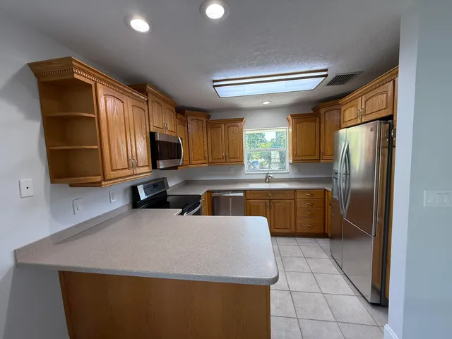 a kitchen with a sink a counter top space cabinets and stainless steel appliances