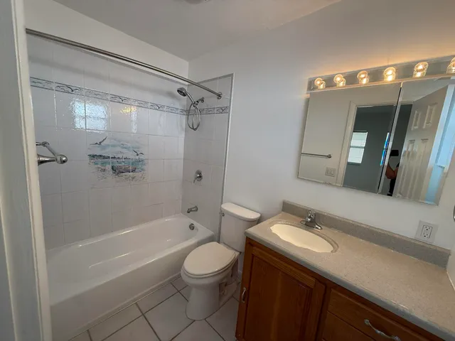 a bathroom with a double vanity sink toilet mirror and shower