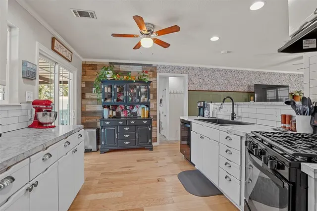 a kitchen with stainless steel appliances kitchen island granite countertop a stove a sink and a refrigerator