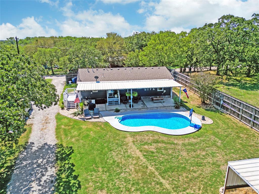 7130 Briar Road Azle, TX 76020 - Photo 6 of 37 a view of a swimming pool with lawn chairs under an umbrella