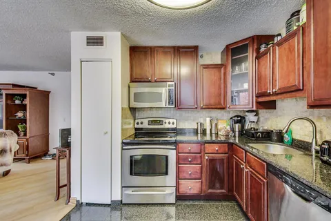 a kitchen with stainless steel appliances granite countertop a stove a sink and a refrigerator
