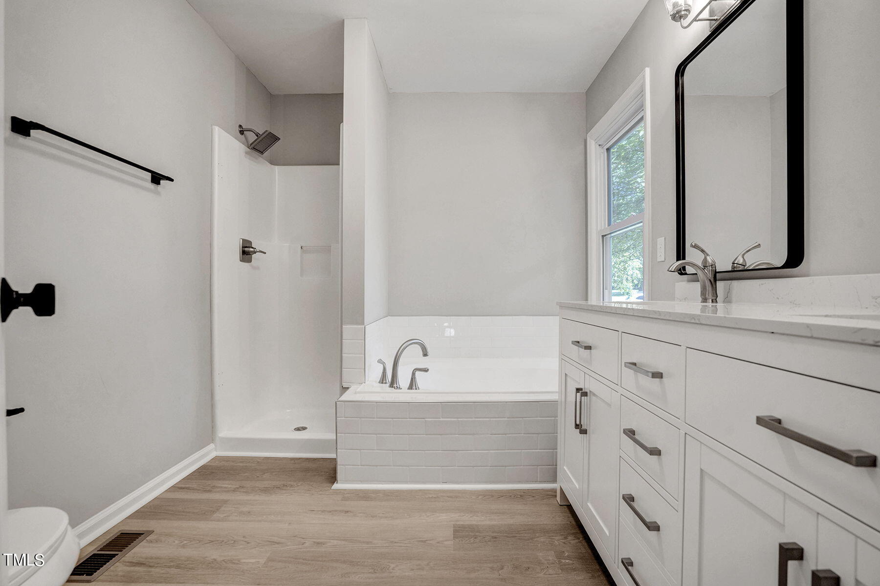 1248 Hillingdon Way Raleigh, NC 27614 - Photo 19 of 32 a bathroom with a bathtub a double vanity sink and mirror