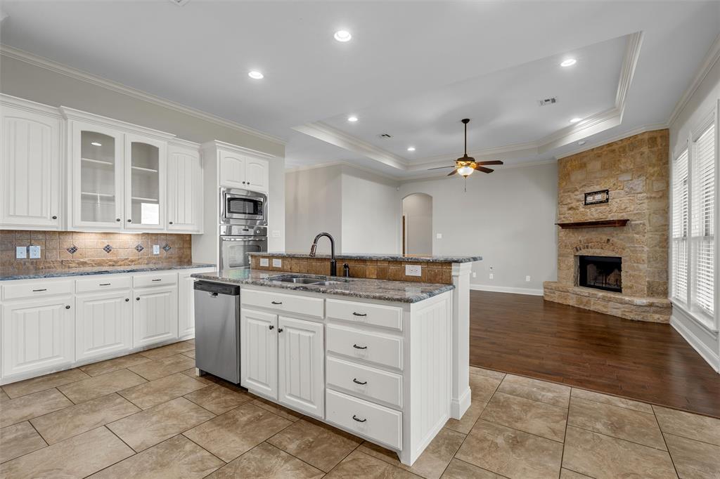 144 Ellis Farm Road Hewitt, TX 76643 - Photo 14 of 36 Kitchen featuring white cabinetry, a central island with a sink, granite countertops, and stainless steel appliances