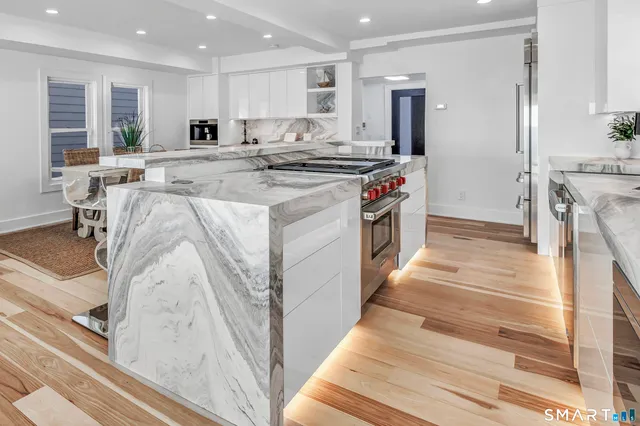 a kitchen with stainless steel appliances granite countertop a stove a sink and a refrigerator