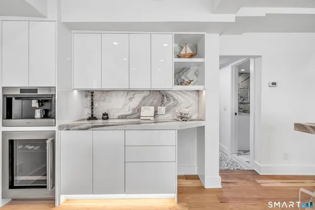 a kitchen with granite countertop white cabinets and white appliances
