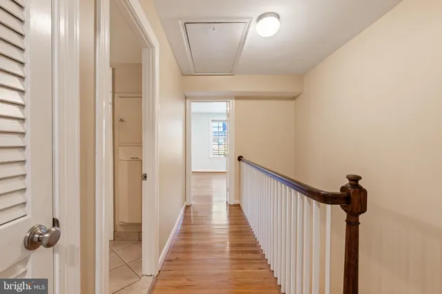 a view of a hallway with wooden floor and staircase