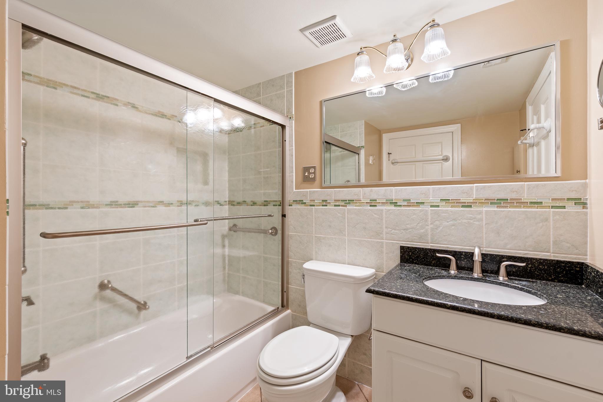 706 6th Street Southwest Washington, DC 20024 - Photo 19 of 39 a bathroom with a granite countertop sink toilet a mirror and shower