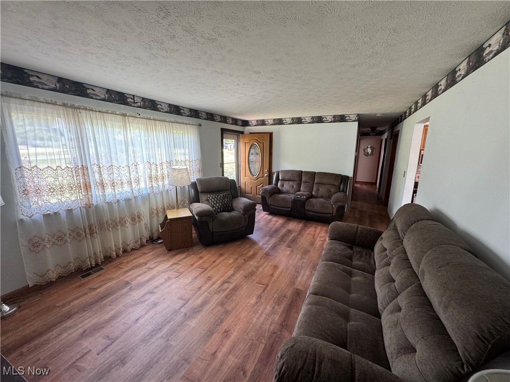 8810 Auburn Road Chardon, OH 44024 - Photo 8 of 22 Living area with wood finished floors and a textured ceiling